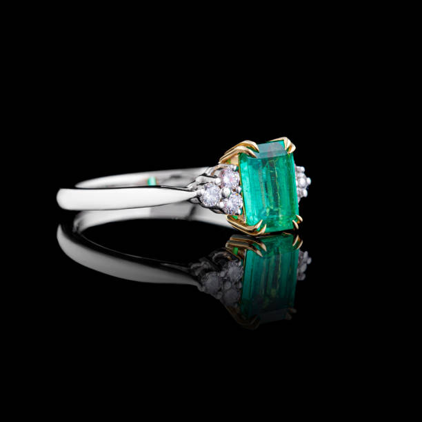 istock beautiful white gold ring with diamonds and emerald on a black background 1629255449