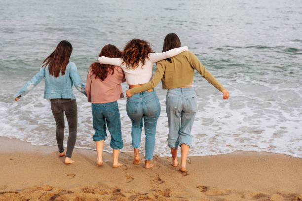 istock Female friends hugging by the ocean 1629260846