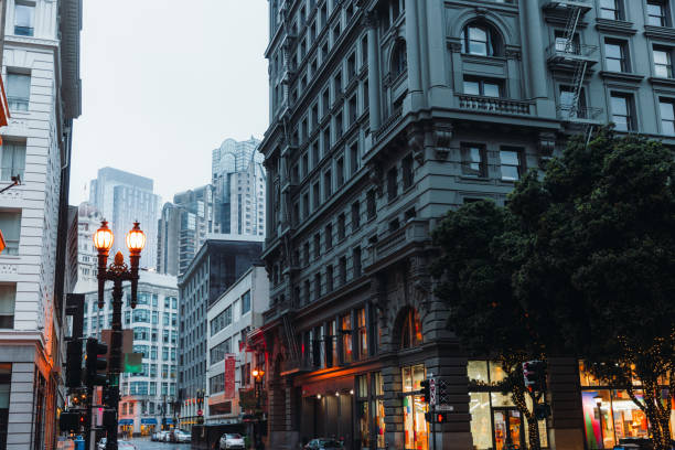 View of Moody Rainy Morning at San Francisco Downtown District, California Dramatic View of modern building exterior of central district of San Francisco city during foggy mist morning, the United States columbus avenue stock pictures, royalty-free photos & images
