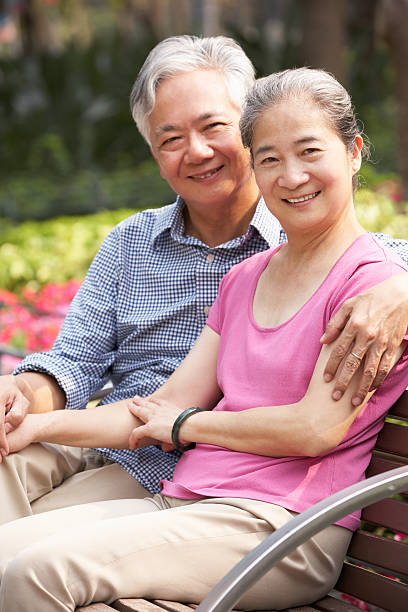 istock Older couple seated on the bench smiling at camera 162927086
