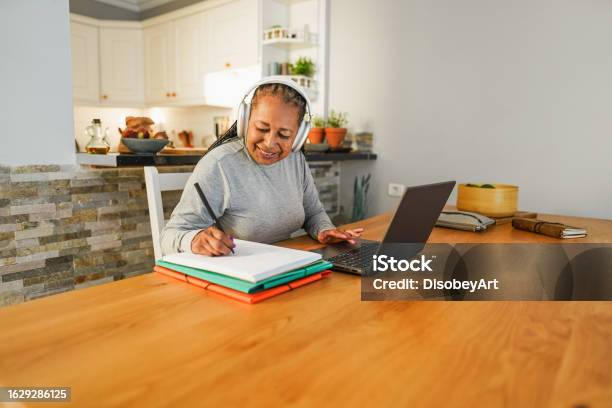 Senior African Woman Doing Digital Class Webinar From Home Joyful Elderly Lifestyle And Technology Concept Focus On Face Stock Photo - Download Image Now
