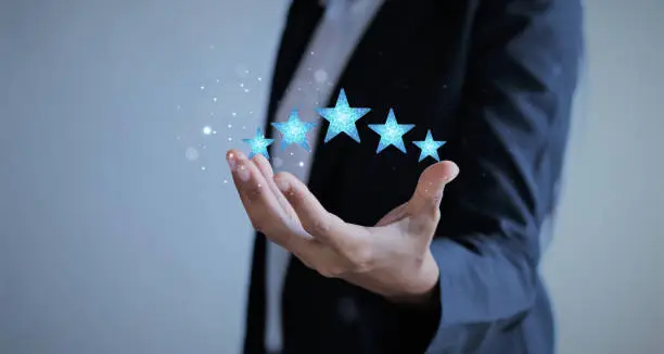 Photo of Five Stars Rating floating on Hand businesswoman.