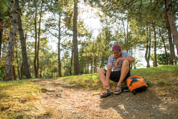 istock Man suffering from pain in ankle while walking in a forest or park 1629304627