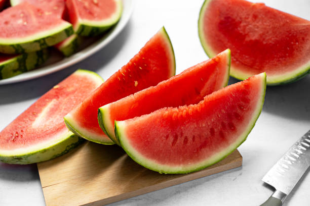 istock Fresh red juicy watermelon slices on cutting board. 1629317328