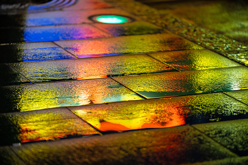 multi coloured reflection on a pavement after the rain