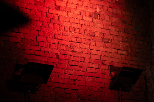 dark brick wall lit by neon light in red
