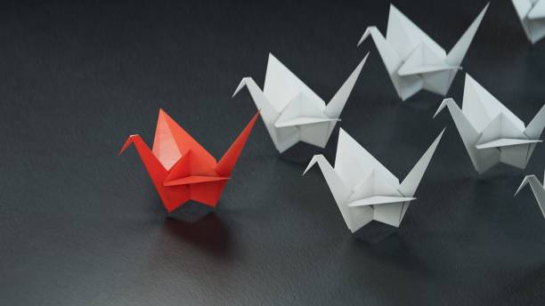 istock Leadership concept with red paper ship leading among white.3D rendering on black background. 1629327762