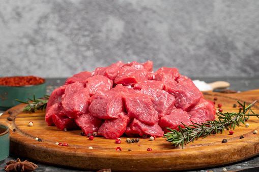 Beef cubed. Fresh raw beef diced meat on dark background. Butcher products. Close up
