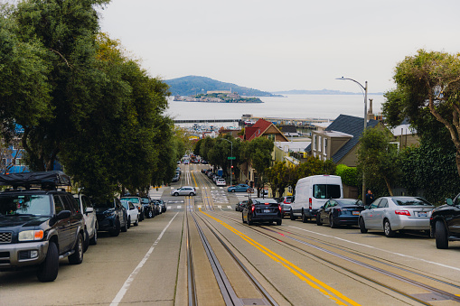 March 19, 2023: walking up the hill of the centre of San Francisco, California with view of the ocean and old Alcatraz jail on the small island