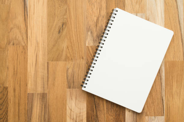 istock Flat lay of open blank spiral notepad or notebook on wooden table background. 1629332613