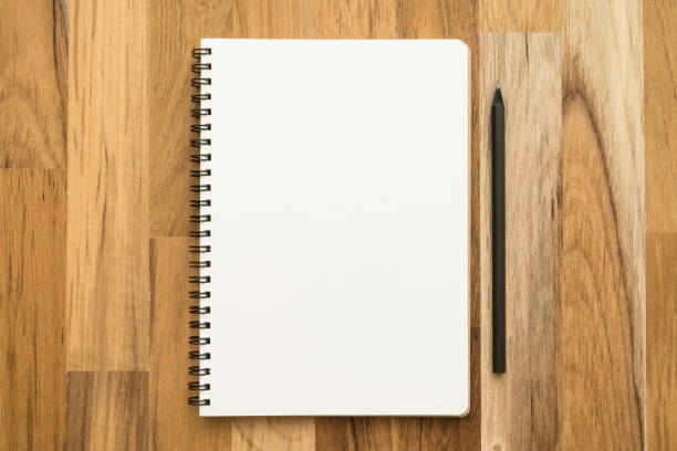 istock Flat lay of open blank spiral notepad or notebook and pencil on wooden table background. 1629332616