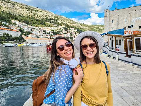 Portrait of two young female tourists in Dubrovnik bay in Croatia.