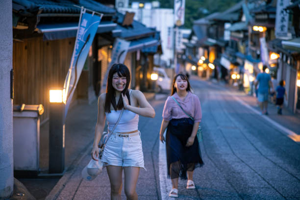 Young female friends walking up slope at night