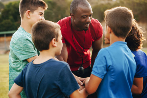 istock Sports coach having a huddle with his school team in a field 1629348370
