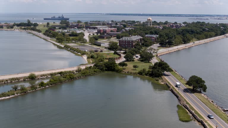 Roads intersections in Fort Monroe on Virginia Peninsula. Mercury Blvd and E Mellen Street cross-section in Fort Monroe, Hampton, VA. Old military ship on the horizon. Aerial footage with panning camera motion