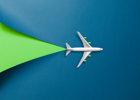 White passenger plane on blue cardboard with a cut out color wedge