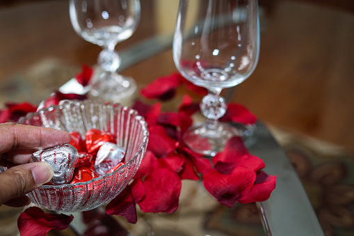 A black woman holding a piece of Valentine Day candy in her hand