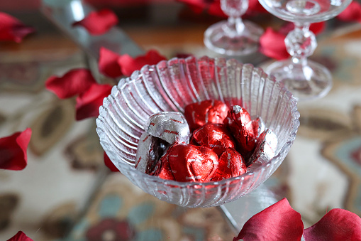 A bowl of chocolate valentine candy sitting on a table
