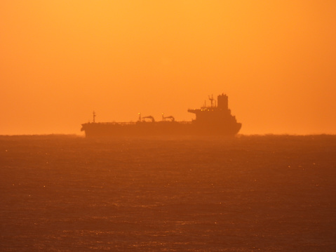 A tanker or bulk carrier offshore from Sydney Harbour. This image was taken from Ben Buckler headland in Bondi at sunrise on 19 August 2023.