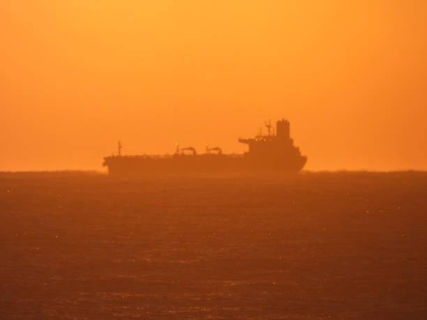 Pacific Ocean Cargo Ship A tanker or bulk carrier offshore from Sydney Harbour. This image was taken from Ben Buckler headland in Bondi at sunrise on 19 August 2023. bondi beach sunrise stock pictures, royalty-free photos & images