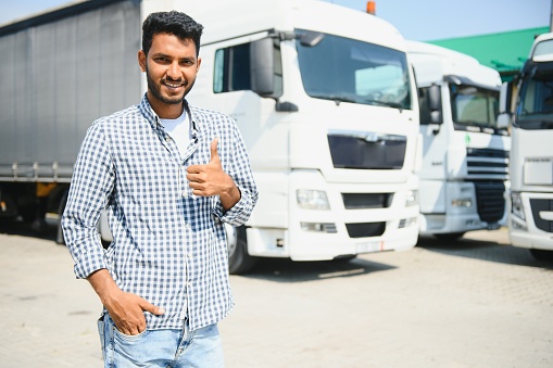 Young indian man standing by his truck. The concept of freight transportation