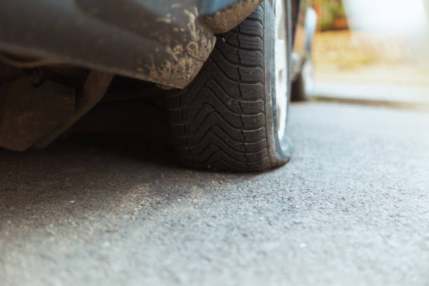 istock Closeup on car with flat tire in city 1629412315