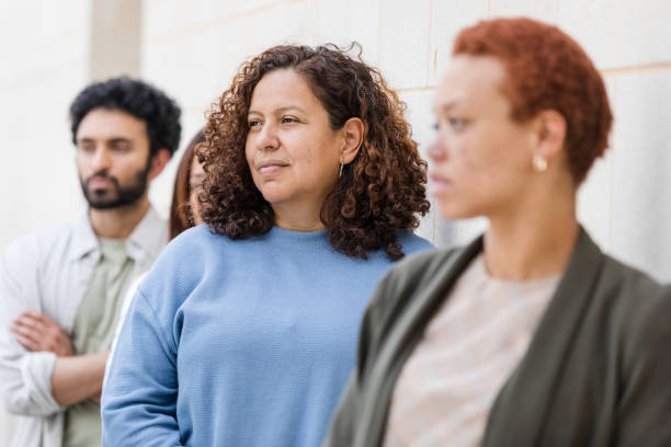 istock Serious, diverse group of adults wait in line 1629420936