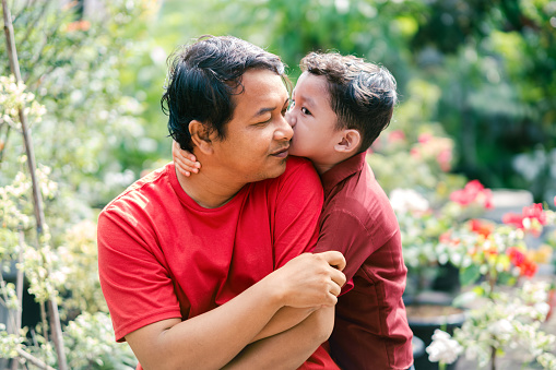 Happy father and son enjoying moment outside together and spread the love. Nature and wellbeing.