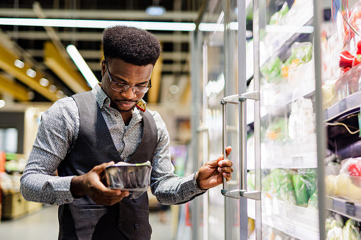 Young African American man shopping in supermarket
