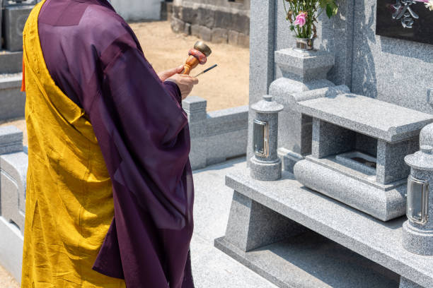 A monk praying in front of the tomb