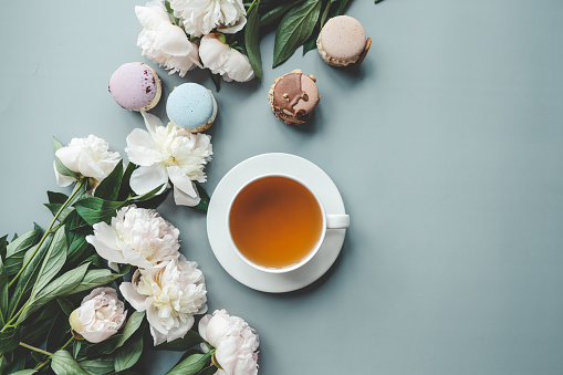 Macaroons and tea on a light background. Sweet French cake.
