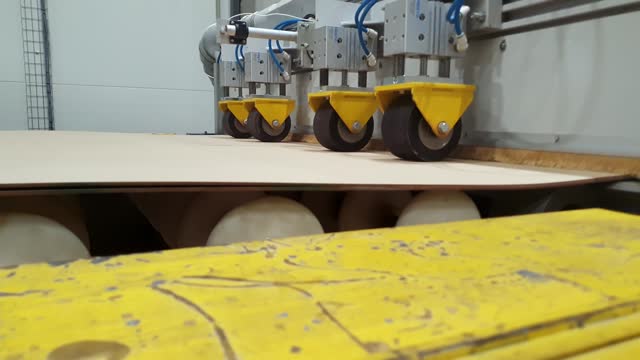 Laminated insulation cardboard production process. Raw materials for laminated cardboard. Electric cardboard travels along the conveyor line. Automated line in production. Roller conveyor. Sphere of the electric network