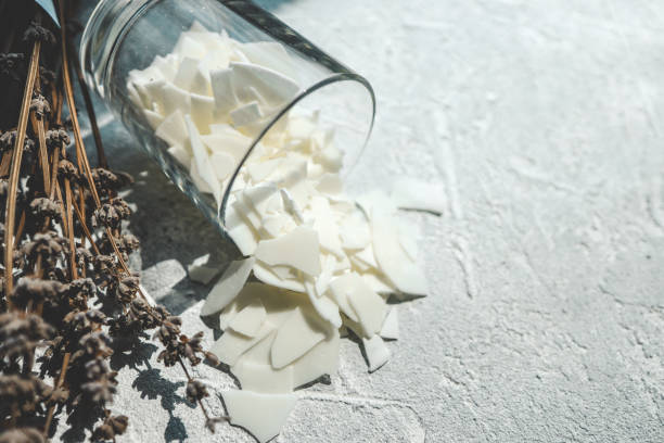 istock Glass with soy wax and lavender, candle making concept 1629477524