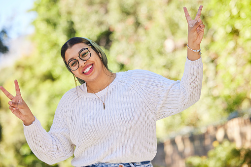 Peace sign, woman and portrait with a smile outdoor of student on summer holiday and vacation. Motivation, gen z and emoji v hand gesture feeling silly with freedom and female person from Sudan