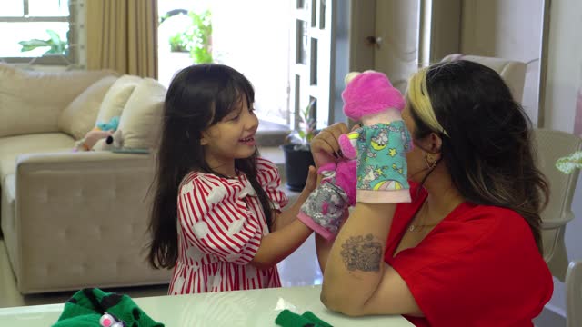 Mother and daughter sharing a hand puppet play moment