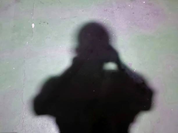 istock blurred image. Take a self-shadow photo against a green painted floor in the background 1629499422
