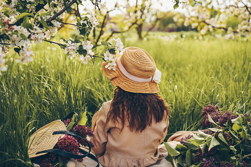 Little girl in a hat in the garden at a picnic.