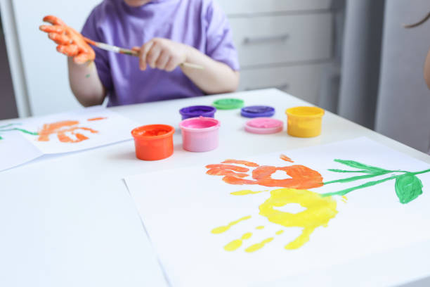 istock Children's art workshop, the child makes a handprint with paints 1629506971