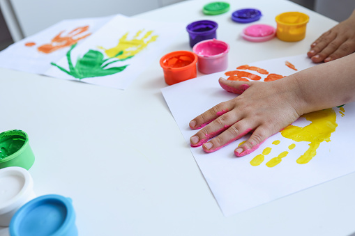Children's art workshop, the child makes a handprint with paints.