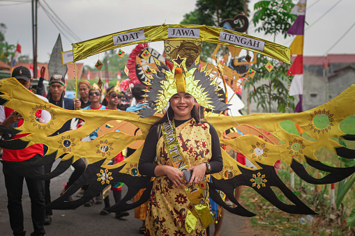 Cilacap, Indonesia august 21, 2023 : a woman wearing an accessory in the shape of a bird's wing like an eagle in order to take part in the carnival celebration of the independence of the republic of Indonesia