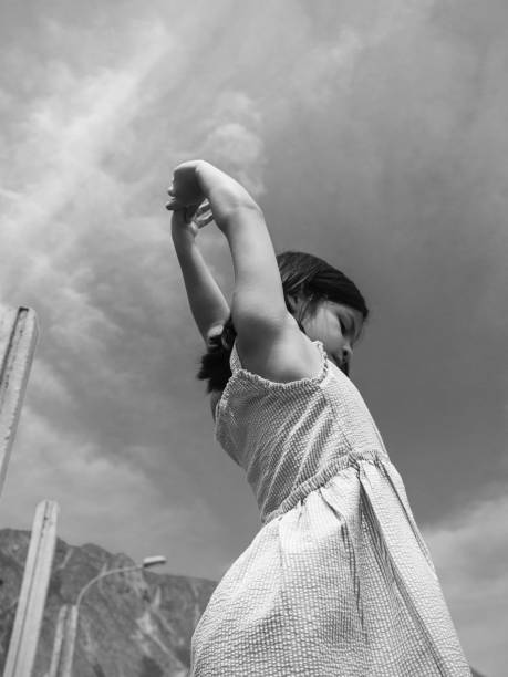 photography in black and white of beautiful girl leaning on a wall with her head lying down, resting a little playing