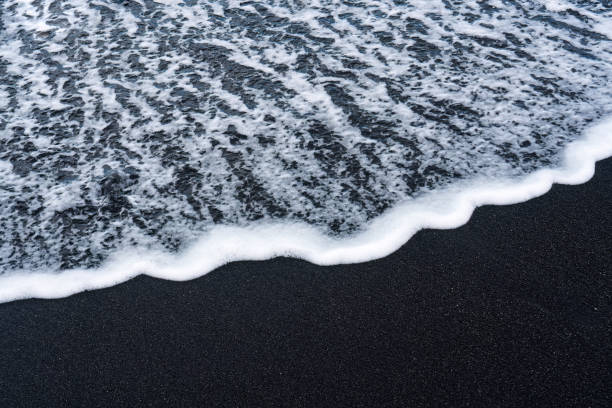 istock Sea wave on volcanic black sand beach in Diamond beach 1629534296