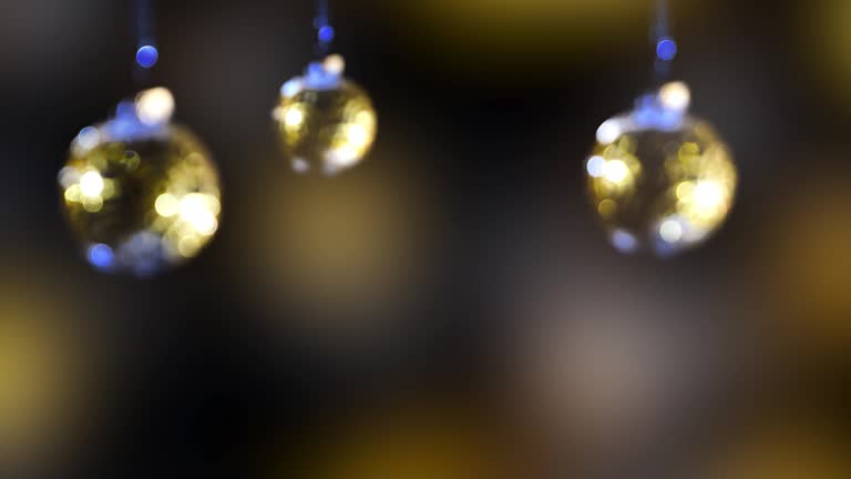 three blurred glittering christmas tree balls hanging on abstract background with copy space, bright bokeh light decoration for merry xmas or happy new years