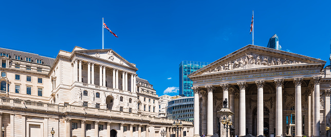 The Bank of England in the heart of the City of London Financial District overlooked by modern skyscrapers.