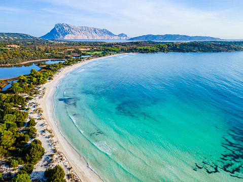 Aerial shot of Cala Brandinchi, one of the most attractive beaches of San Teodoro, that let you see the turquoise water in front, the pond behind, and furthermore, in background, the Island of Tavolara