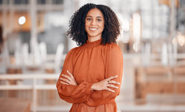 Smile, arms crossed and portrait of a woman at work for business pride and corporate confidence. Happy, office and a young employee with career empowerment and job motivation in the workplace stock photo