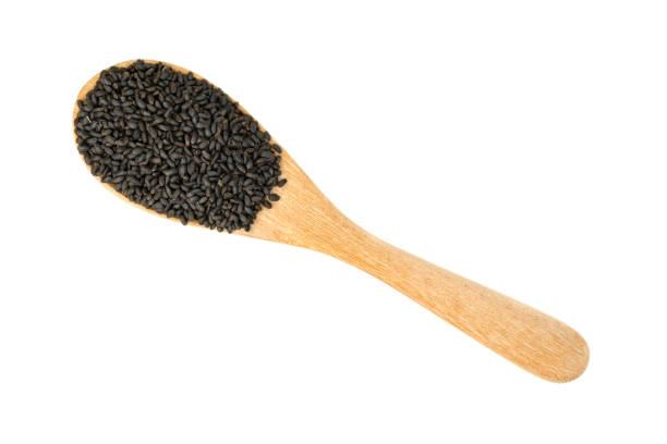 istock Hairy basil seeds in wooden spoon isolated on white background 1629558464
