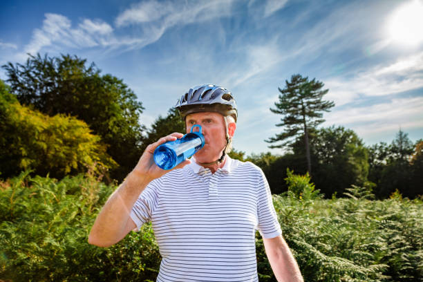 istock Senior male cyclist drinking from water bottle on forest trail 1629564255