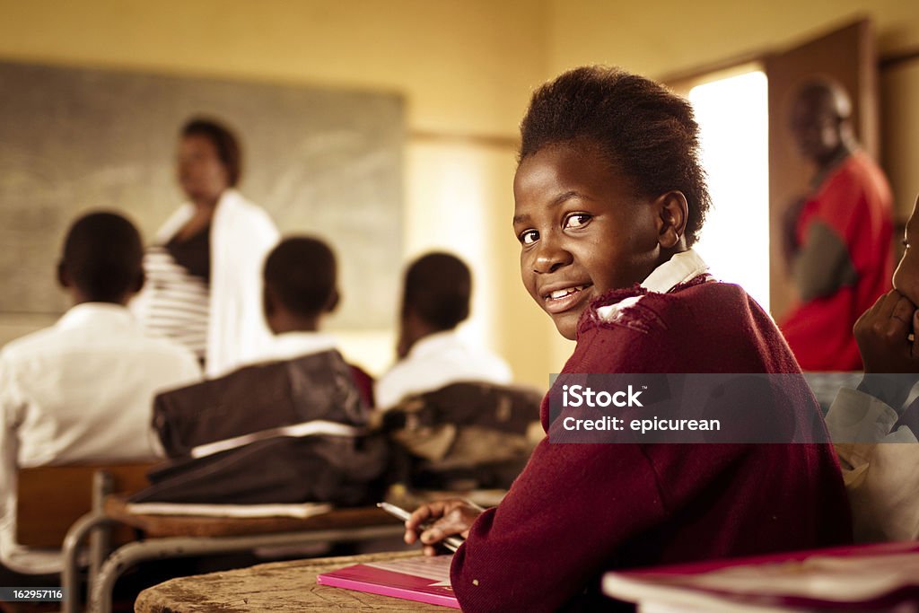 Portrait of happy Young South African girl in classroom South African girl (from the Xhosa tribe) works on her studies at an old worn desk in a class room in the Transkei region of rural South Africa. Africa Stock Photo