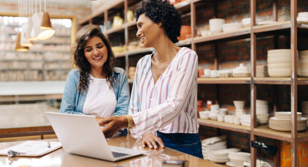istock Smiling ceramists using a laptop together in their shop 1629576179